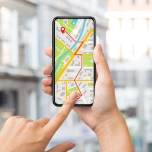 Navigation App With Street Map Opened On Smartphone In Female Hands creazione sito web hotel visibilità SEO