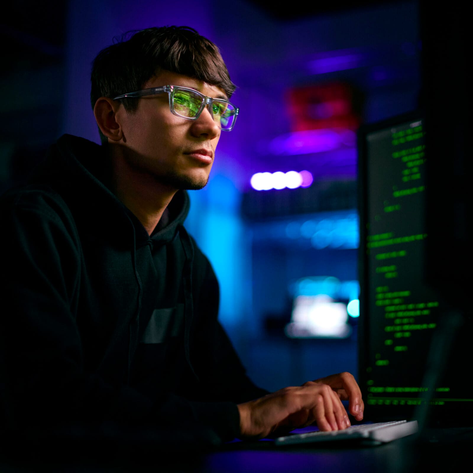 Low Key Lighting Shot Of Male Computer Hacker Sitting In Front Of Screens Breaching Cyber Security Manutenzione sito web