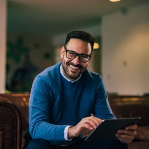 Portrait of a happy businessman working over the digital tablet with glasses on. siti web per hotel