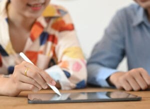 A cropped image of a graphic design team is using a tablet at th prezzi siti web