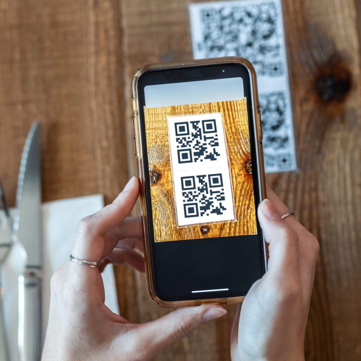 Young woman hands using the smart phone to scan the qr code to s menu QR code ristorante